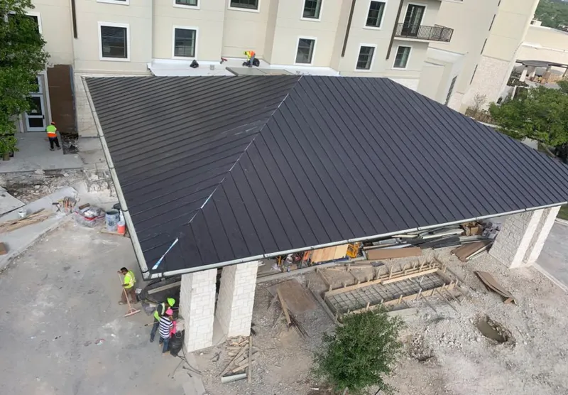 Metal roofing installation team working on a commercial building in Scottdale